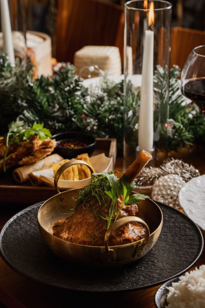 lamb shank in copper pot dressed with fresh herbs